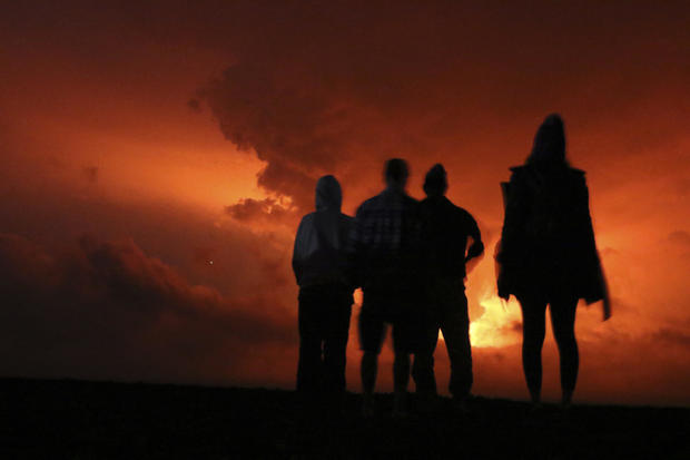 People watch the glow from lava erupting from Hawaii's Mauna Loa volcano Nov. 28, 2022, in Hilo, Hawaii. 