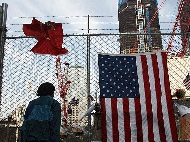 A man views construction at the World Trade Center site as the new One World Trade Center rises behind after the death of accused 9/11 mastermind Osama bin Laden May 3, 2011 