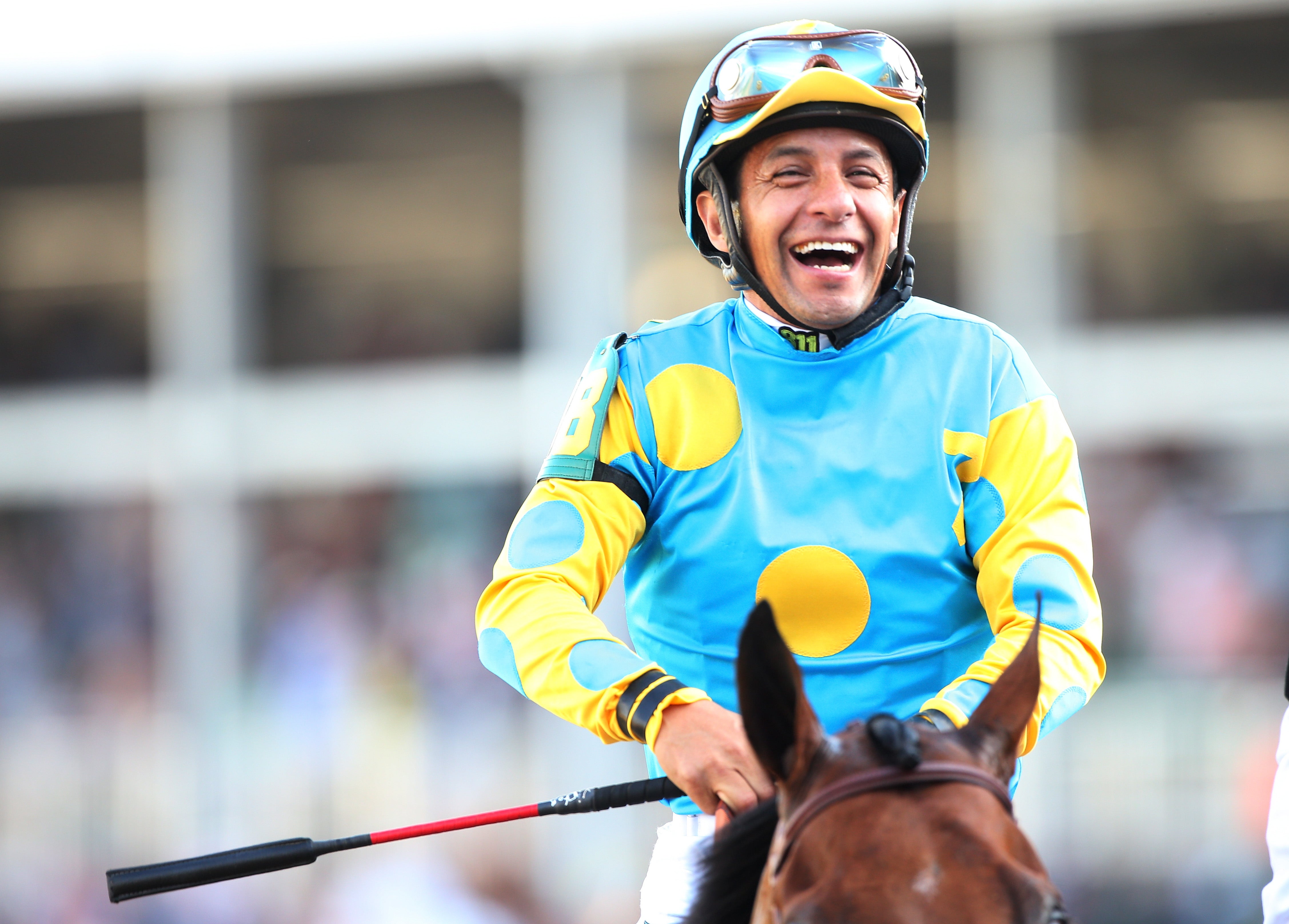 Triple Crown winning jockey Victor Espinoza waves to the crowd before  throwing out the ceremonial first pitch before the baseball game between  the Arizona Diamondbacks and San Diego Padres in a baseball