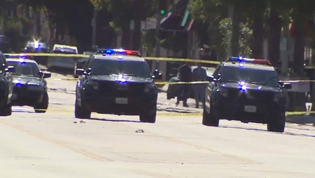 Los Angeles police shoot armed suspect on busy street - CBS News