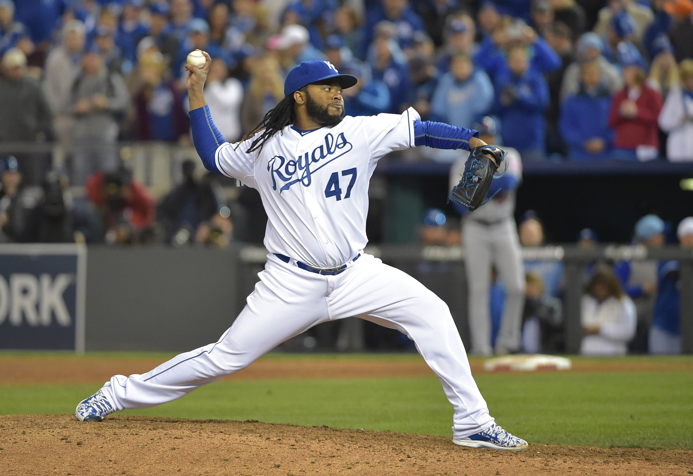 Kansas City Royals fans hold up pictures of starting pitcher Johnny Cueto  and catcher Salvador Perez as he Royals face the New York Mets in game 2 of  the World Series at