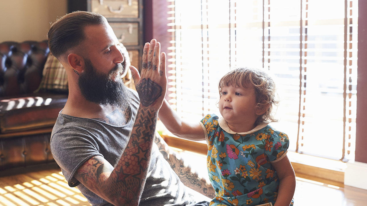 Dad and toddler daughter doing high-five 