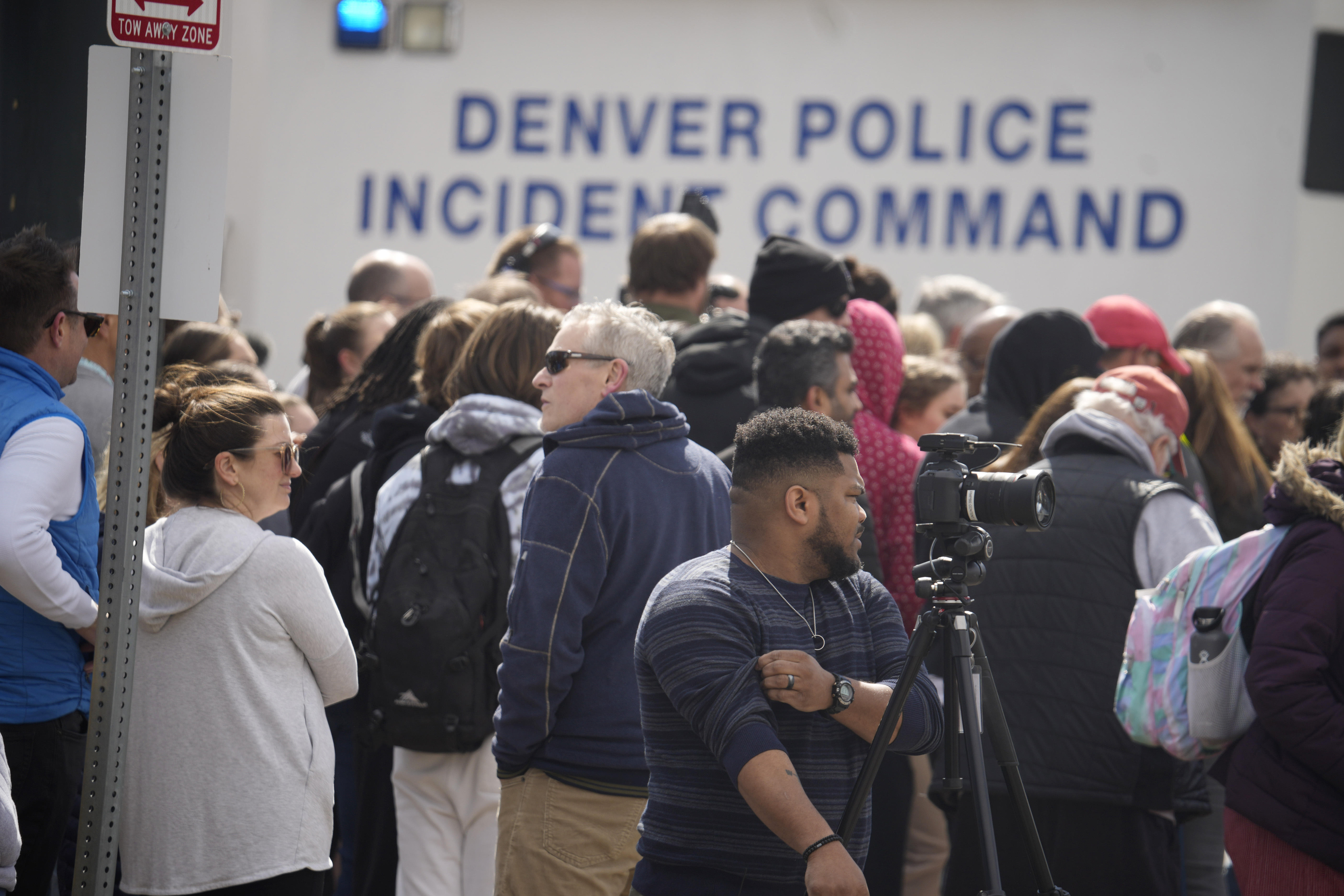 Parents wait for students to be walked out after two administrators were shot and wounded after a handgun was found during a daily search of a student at Denver's East High School March 22, 2023. 