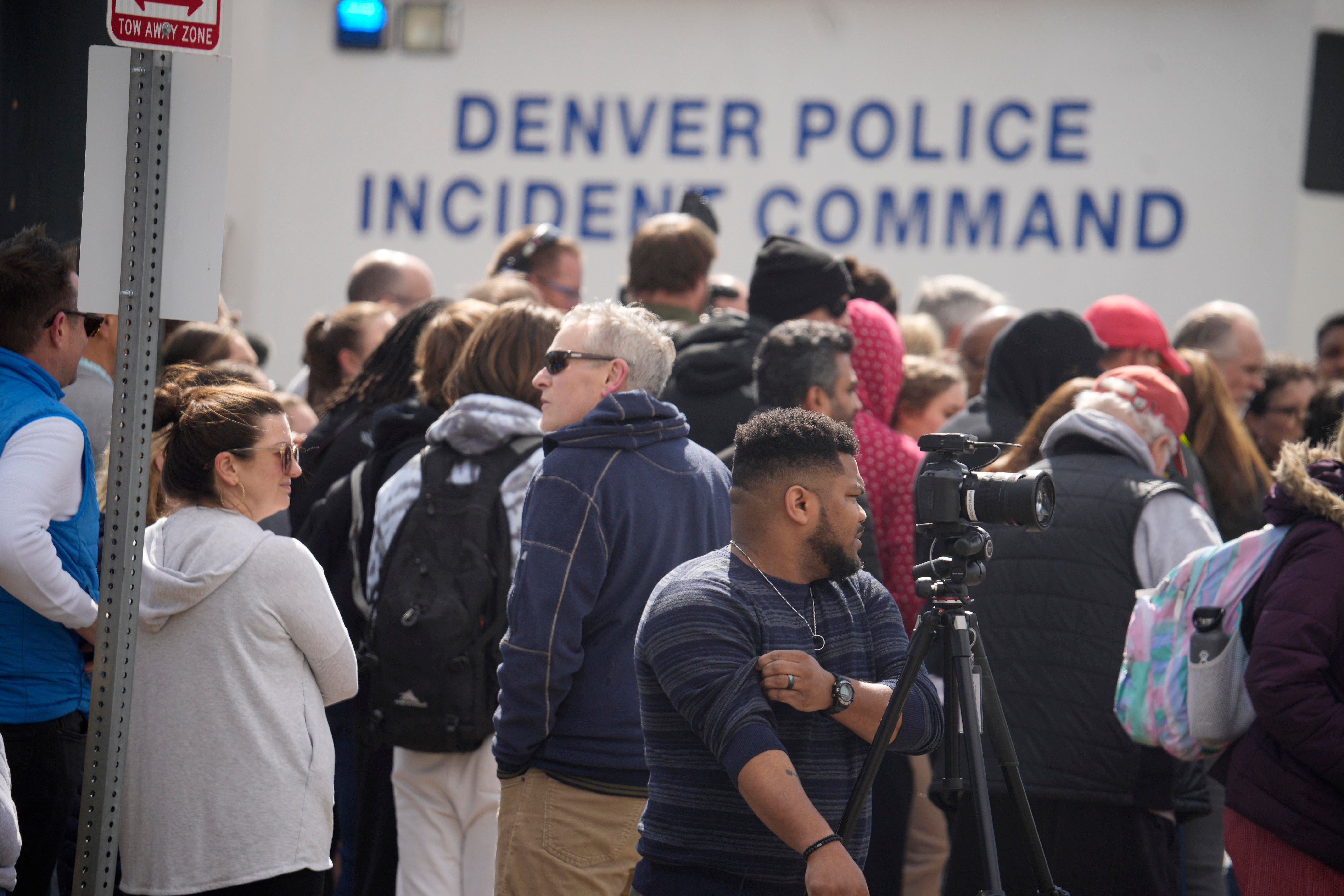Parents wait for students to be walked out after two administrators were shot and wounded after a handgun was found during a daily search of a student at Denver's East High School March 22, 2023.