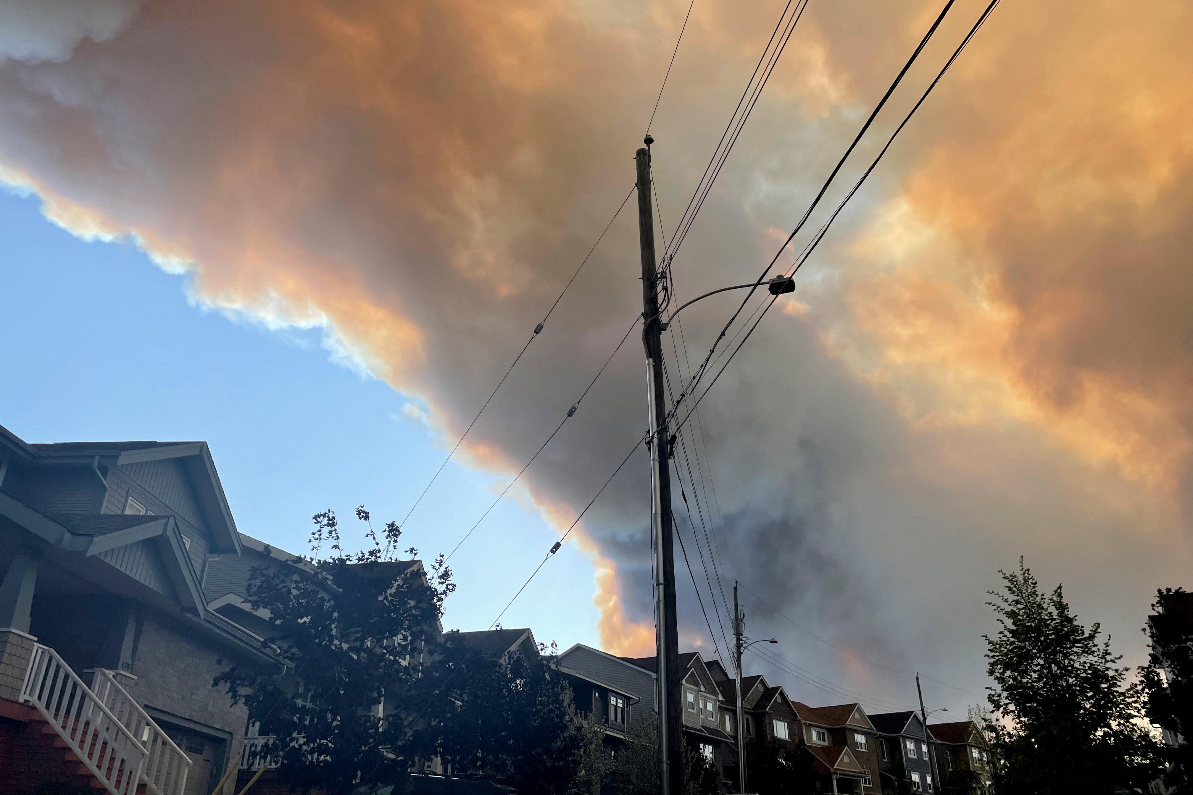 Smoke from the Tantallon wildfire rises over houses in nearby Bedford, Nova Scotia, Canada, May 28, 2023. 