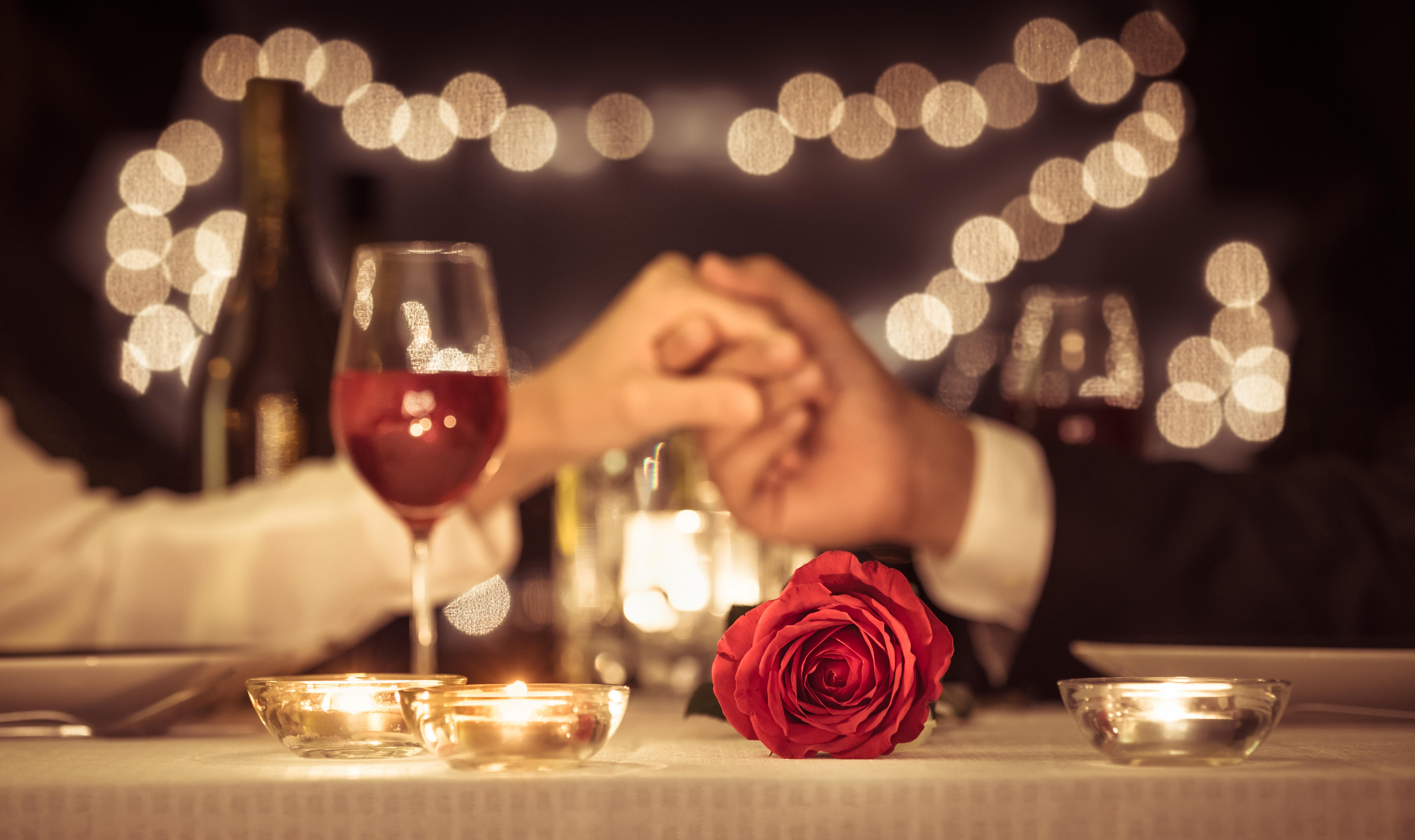 Couple holding hands having a romantic dinner date.