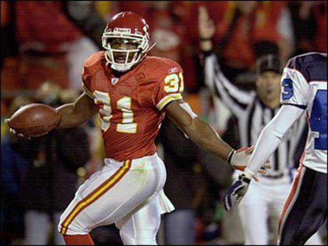 Priest Holmes of the Kansas City Chiefs runs the ball past Jason