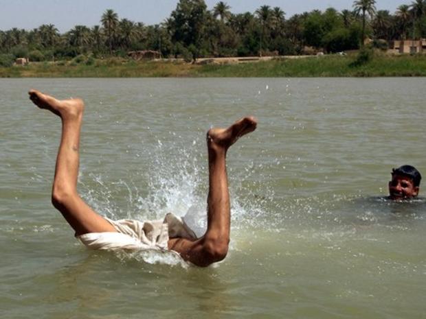 An Iraqi boy dives into the Euphrates river 