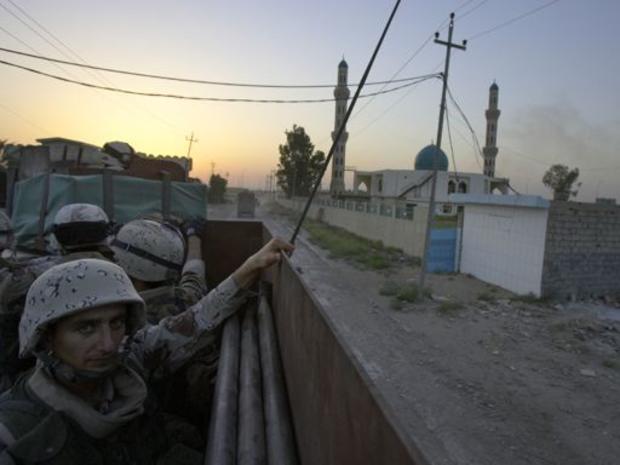 Iraqi soldiers ride in the back of a truck 