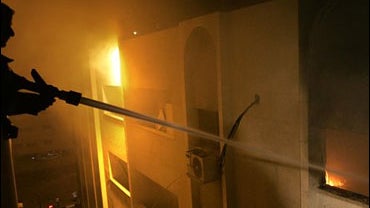 firefighter uses water to extinguish the flames in the Palestinian Authority Interior Ministry 