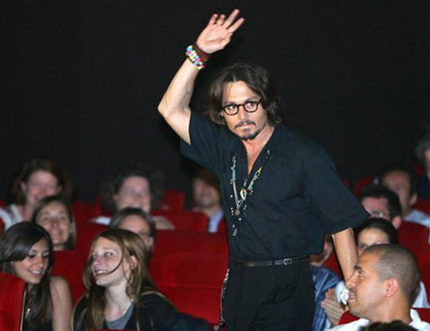 Actor Johnny Depp waves to fans prior to the screening for the French premiere of his latest movie "Pirates of the Caribbean: Dead Man's Chest," in Paris, Thursday July 6, 2006. (AP Photo/Remy de la Mauviniere) 