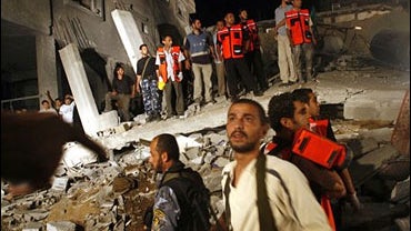 Palestinians gather in the rubble of a house destroyed in an explosion in Gaza City, July 12, 2006. 
