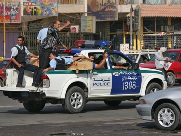Iraqi police shoot in the air to honor a fellow officer killed in a restaurant grenade attack 