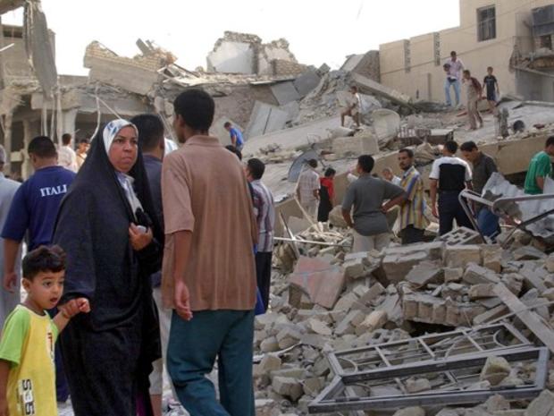 An Iraqi boy with his mother looks at the damaged mosque 