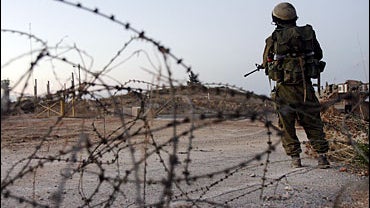 An Israeli soldier looks at a UN position in Lebanon, on the Israel-Lebanon border 
