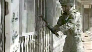 CBS News Exclusive: A U.S. soldier breaks the lock on a home in the Dora neighborhood of Baghdad. 