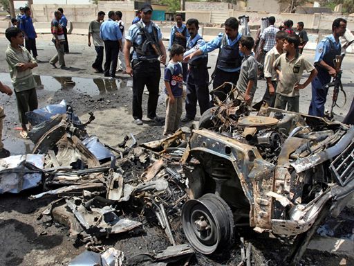 Iraqi policemen question a child at the site of a car bomb explosion, in Baghdad, Iraq 