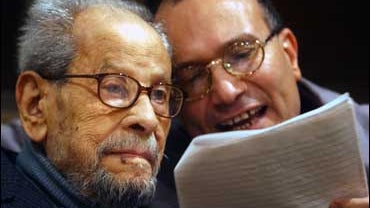 Naguib Mahfouz, Egyptian novelist and Nobel laureate in 1988, left, listens to Ibrahim Abdel Aziz, an Egyptian journalist, as he reads for him the latest laureate news in this Dec. 8, 2004 file photo, in Cairo, Egypt. 