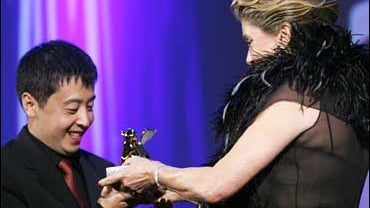 Director Jia Zhangke of China, left, receives the Golden Lion, the Festival's top award, for his movie "Sanxia Haoren" (Still Life) at the 63rd edition of the Venice film festival from jury president Catherine Deneuve, in Venice, Italy, Saturday, Sept. 9, 