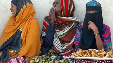 A Somali woman, right, waits for travelers to buy samosas 