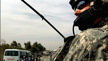 Staff Sergeant Justin Schaffer of the US army's 172nd Stryker Brigade Combat team keeps watch October 2, 2006 as his colleagues search bus passengers in east Baghdad. 