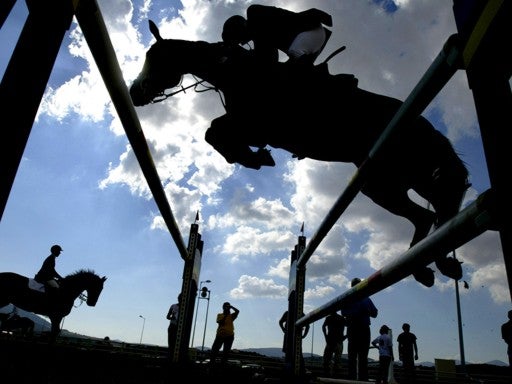 An unidentified athlete warms up as he jumps a fence with his horse at the Olympic Equestrian Center in Markopoulo, 40 Km from Athens 