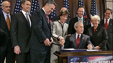 President Bush, seated at table, gets ready to sign the Security and Accountability For Every (SAFE) Port Act 