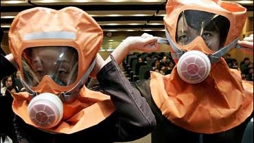 South Korean office workers put on gas masks as they take part in civil defense drill 
