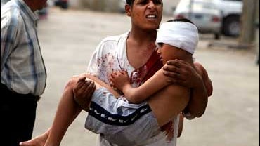 A young man carries a boy out of a hospital in Baghdad, Iraq, after the youth received medical treatment Sunday Oct. 22, 2006. 