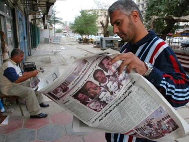 Iraqis read newspapers carrying front page stories on the death penalty verdict for former Iraqi leader Saddam Hussein in Baghdad, Iraq, Tuesday Nov. 7, 2006. 
