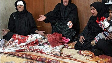 Iraqi women react at their home following a military raid in the Shiite district of Sadr City in Baghdad 