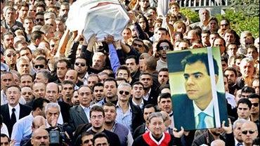 The coffin and a poster of assassinated Christian politician Pierre Gemayel are carried towards the family home in Bikfaya, Lebanon 