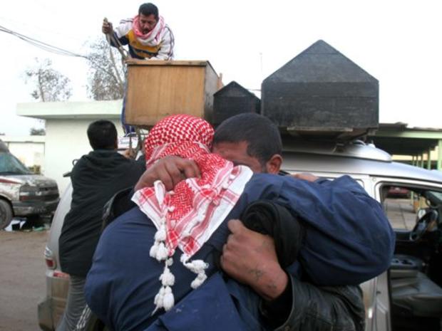 Men embrace after collecting bodies of their four relatives killed when their house was destroyed in Sadr City, Baghdad, Iraq, Wednesday Jan. 10, 2007. 