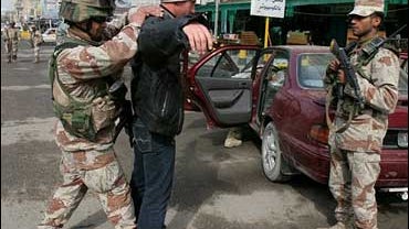 An Iraqi army soldier searches a driver on a vehicle checkpoint in central Baghdad, Iraq, Wednesday, Feb. 7, 2007. 