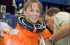 Astronaut Lisa M. Nowak, STS-121 mission specialist, dons a training version of the shuttle launch and entry suit 