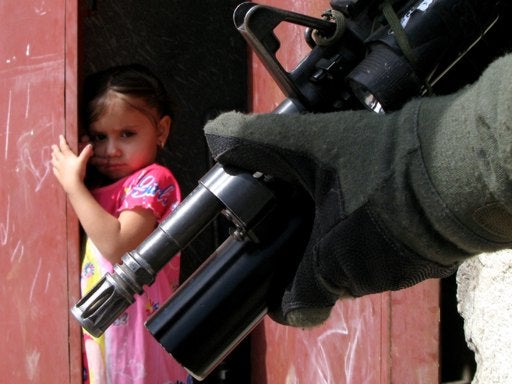 Iraqi girl looks at a US soldier on a patrol in the Shiite enclave of Sadr City in Baghdad, Monday, March 19, 2007. 