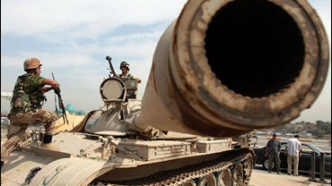 Iraqi soldier climbs on top of a tank at a checkpoint in Baghdad March 21, 2007. 