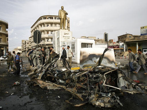 US soldiers and Iraqi security forces secure the site of a suicide car bomb attack at Baghdad's al-Rusafi square 