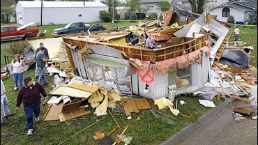 Friends and neighbors sort through the reckage of a trailer home belonging to Breck and Becky Grabast Sunday, May 6, 2006 in Osborne, Kan.. 