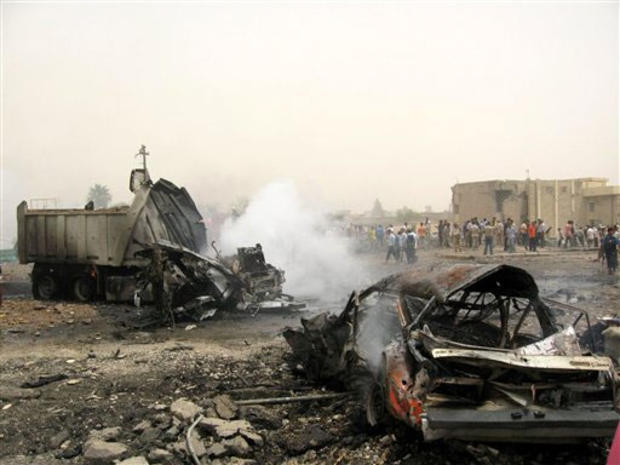 Smoke rises from the wreckage of a truck used in the first of two suicide car bombings in Kirkuk, 290 kilometers (180 miles) north of Baghdad, Iraq, Monday, July 16, 2007. 