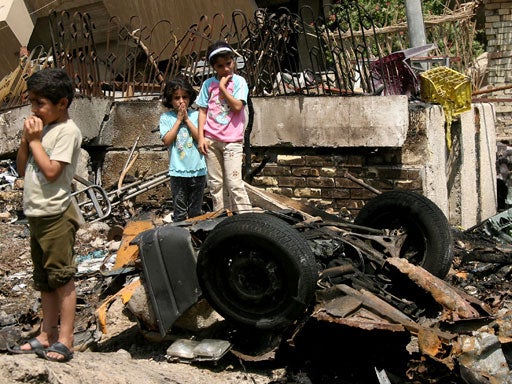 Iraqi kids look at what remained from a car that was used in a attack in neighborhood of Mansour in western Baghdad, Iraq on Wednesday, Aug. 29, 2007. 