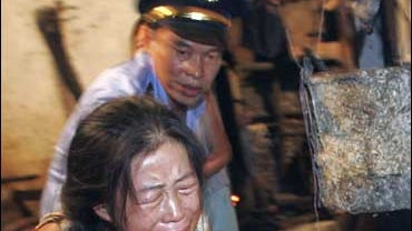 A Chinese woman struggles with police during a raid on an illegal bean curd shop 