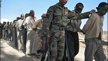Iraqi soldier with suspects in Baquba 