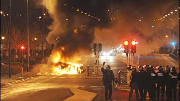 Policemen patrol as cars are burning in Villiers-Le-Bel, north of Paris 