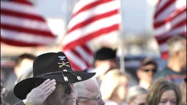 Col. Bill Dolan salutes as taps is played for Third Armored Calvary Division Cpt. Rowdy J. Inman 