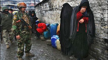 An Iraqi woman gestures as she reacts to her plight after waiting in a queue to buy petrol for three days 