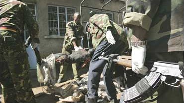 police unload a charred body at the mortuary in Nakuru, Kenya, a victim of election violence 