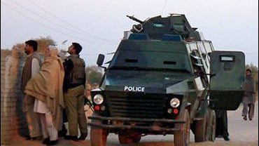 An armored police car is seen parked outside a school where a gang of criminals who had taken dozens of school children and teachers hostage in Bannu 