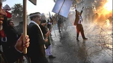 Pakistani lawyers are blasted with a water canon and tear gas as they demonstrate against the government of Gen. Pervez Musharraf 