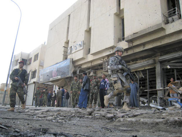 A U.S. soldier and members of the Iraqi army secure the scene of a car bombing in central Baghdad, Iraq, Monday, Feb. 11, 2008. 